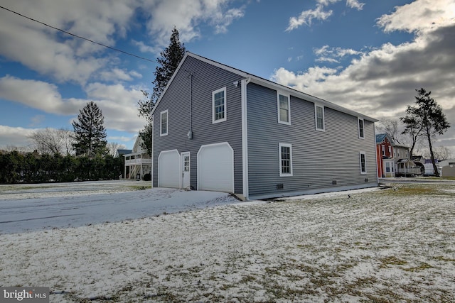 snow covered property featuring a garage