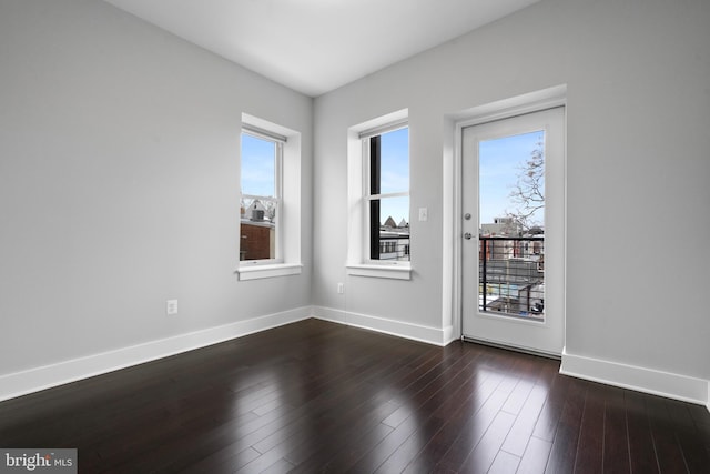 unfurnished room with dark hardwood / wood-style flooring