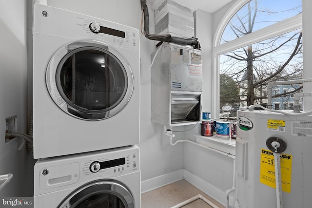 laundry room featuring electric water heater and stacked washer and dryer