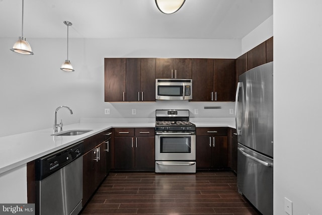 kitchen with dark brown cabinetry, appliances with stainless steel finishes, sink, and pendant lighting