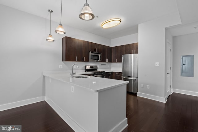 kitchen with appliances with stainless steel finishes, decorative light fixtures, sink, kitchen peninsula, and electric panel