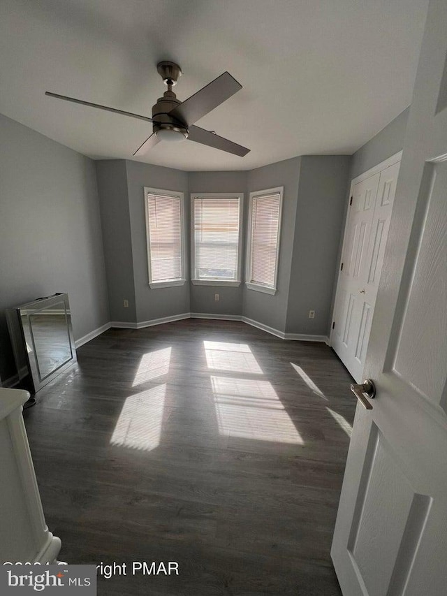 spare room with dark hardwood / wood-style flooring and ceiling fan