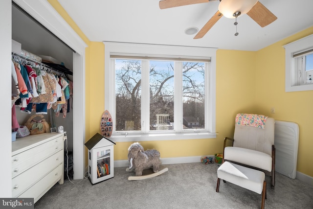 living area featuring carpet floors and ceiling fan