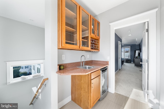 kitchen featuring light carpet, sink, and stainless steel dishwasher