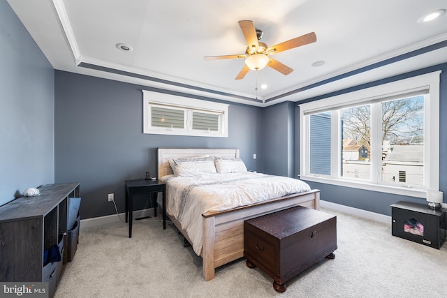 bedroom featuring a raised ceiling, light colored carpet, and ceiling fan