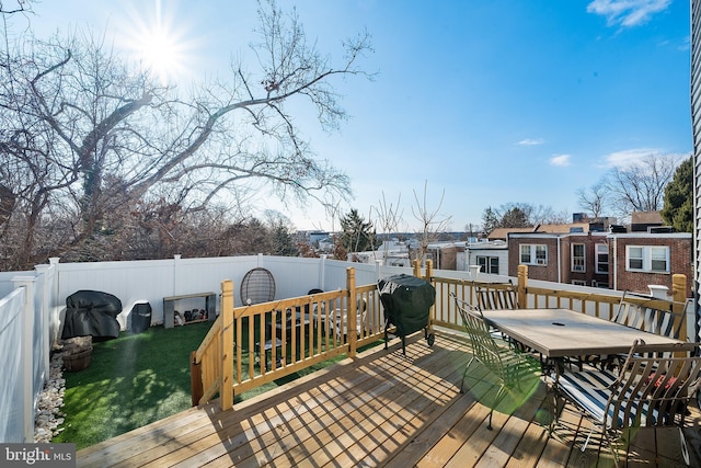 wooden terrace with area for grilling and a yard