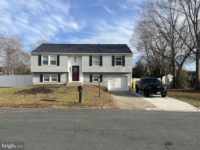 bi-level home with a garage and a front lawn