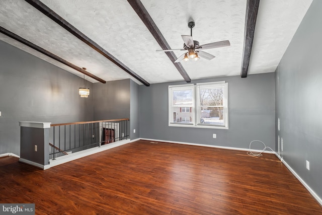 spare room featuring a textured ceiling, ceiling fan, lofted ceiling with beams, and dark hardwood / wood-style floors