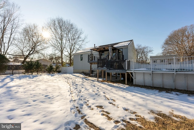 snow covered house with a wooden deck