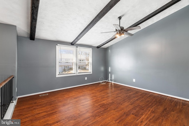 empty room featuring hardwood / wood-style flooring, a textured ceiling, ceiling fan, and vaulted ceiling with beams