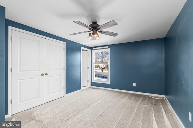 unfurnished bedroom with ceiling fan, a closet, and carpet floors