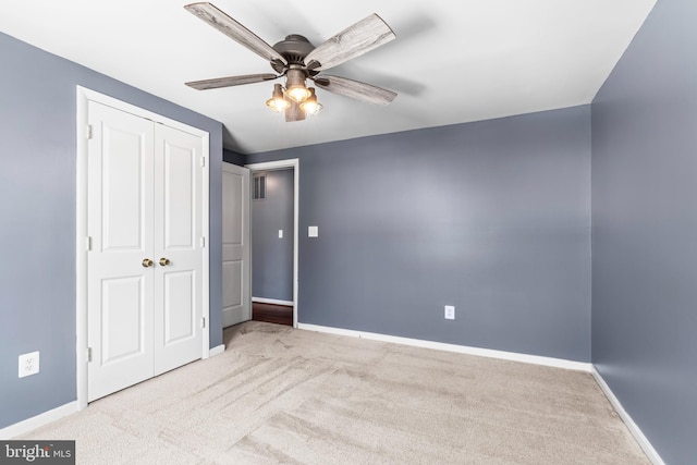 unfurnished bedroom with ceiling fan, a closet, and light carpet