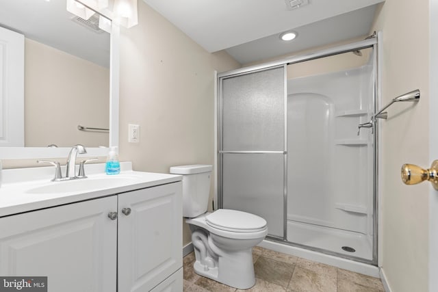 bathroom featuring toilet, a shower with door, and vanity