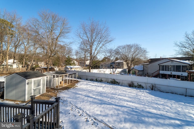 yard covered in snow featuring a storage shed