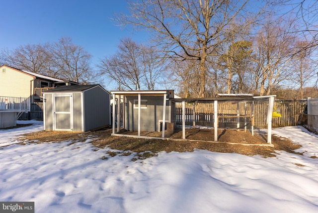 yard covered in snow featuring a storage shed