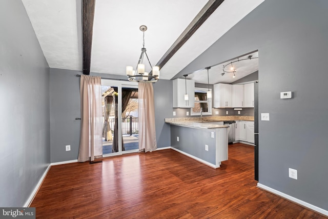 kitchen with white cabinets, vaulted ceiling with beams, hanging light fixtures, a notable chandelier, and dark wood-type flooring