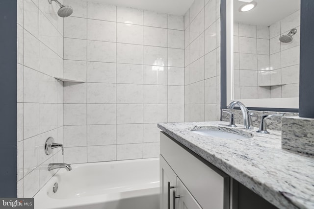 bathroom with tiled shower / bath combo and vanity