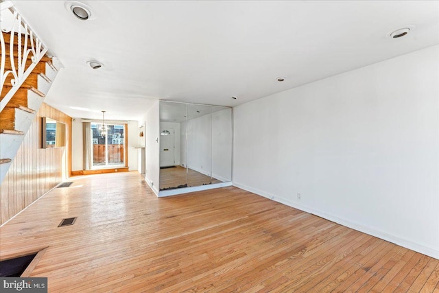 spare room with light hardwood / wood-style floors and a chandelier