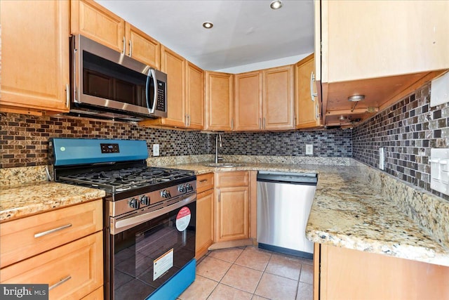 kitchen with stainless steel appliances, decorative backsplash, sink, and light tile patterned floors