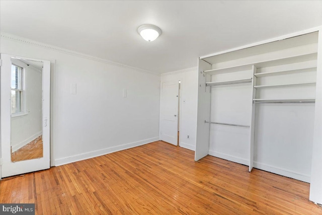 unfurnished bedroom with light wood-type flooring and a closet