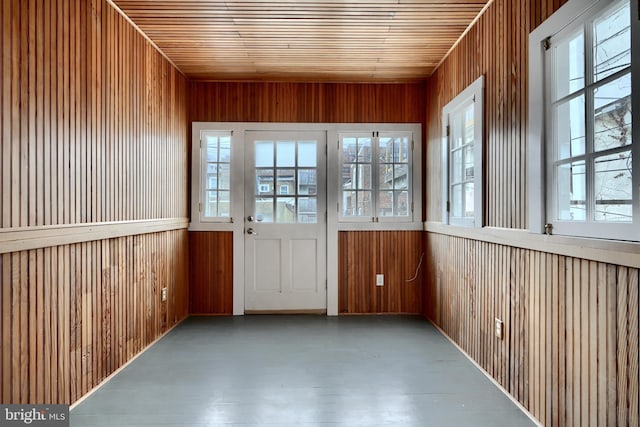 unfurnished sunroom featuring a healthy amount of sunlight and wood ceiling