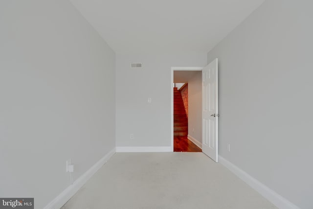 carpeted empty room with visible vents and baseboards