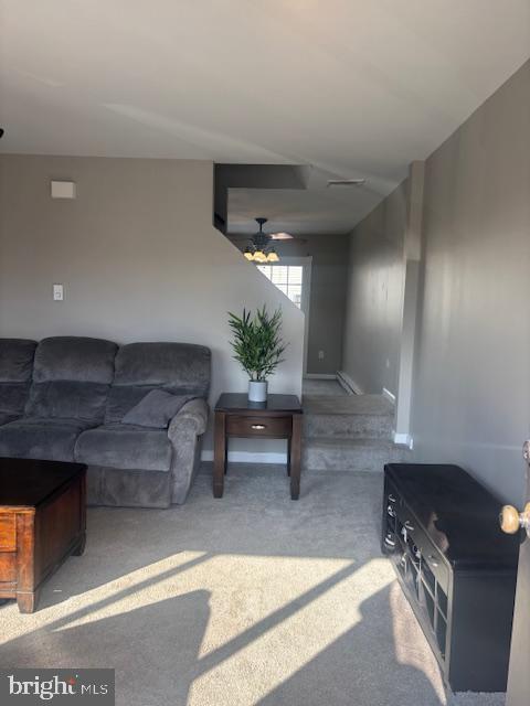 carpeted living room with ceiling fan