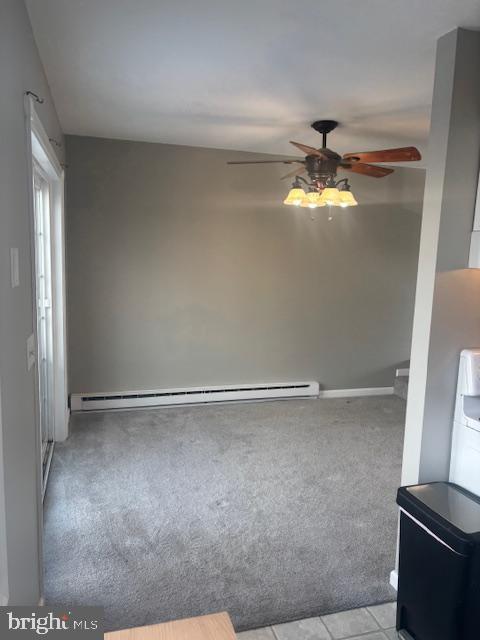 empty room featuring baseboard heating, ceiling fan, and light tile patterned floors