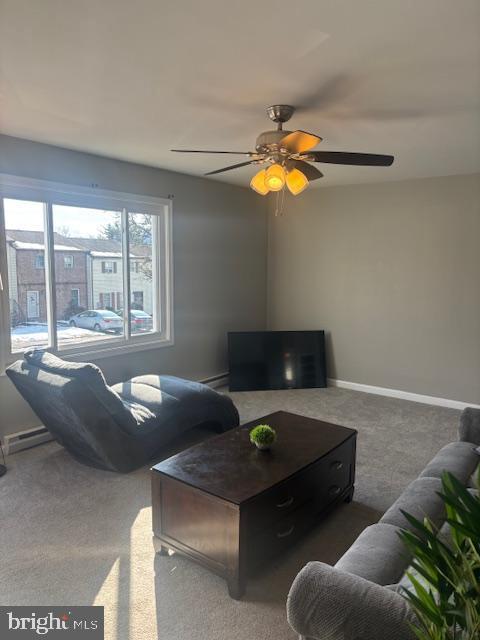 carpeted living room with ceiling fan and a baseboard radiator