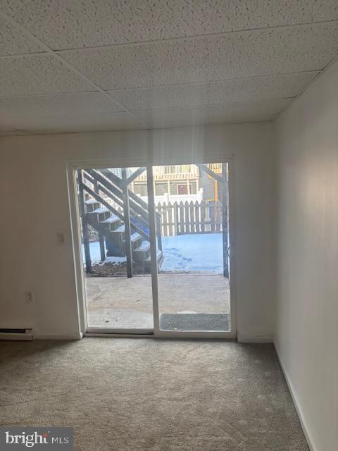 unfurnished room with a paneled ceiling and carpet