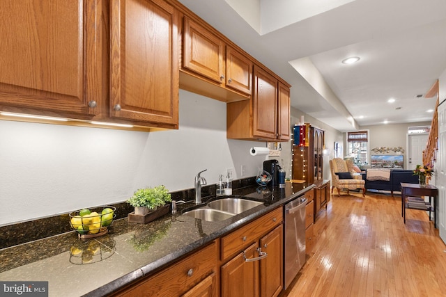 kitchen with sink, light hardwood / wood-style flooring, dishwasher, and dark stone countertops