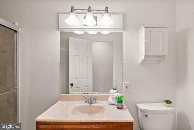 bathroom featuring toilet, an enclosed shower, and vanity