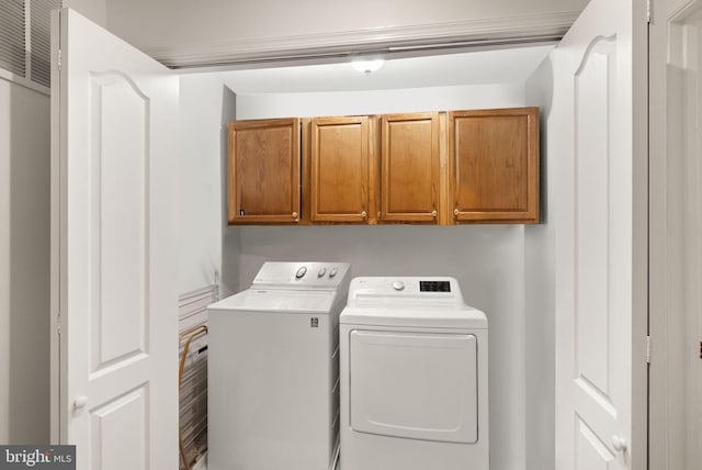 washroom with washing machine and dryer and cabinets