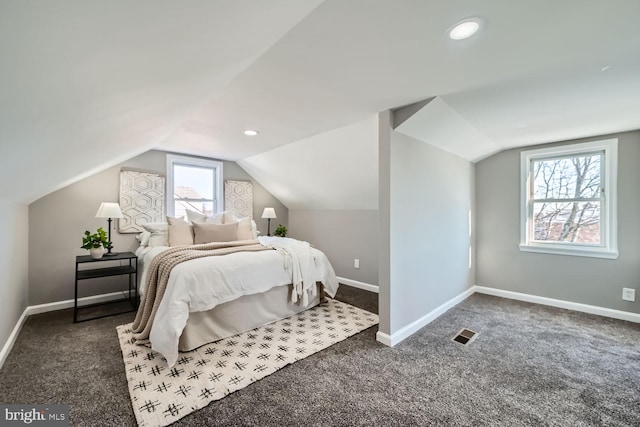 carpeted bedroom with lofted ceiling and multiple windows