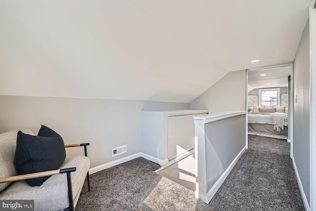 interior space with lofted ceiling and dark carpet