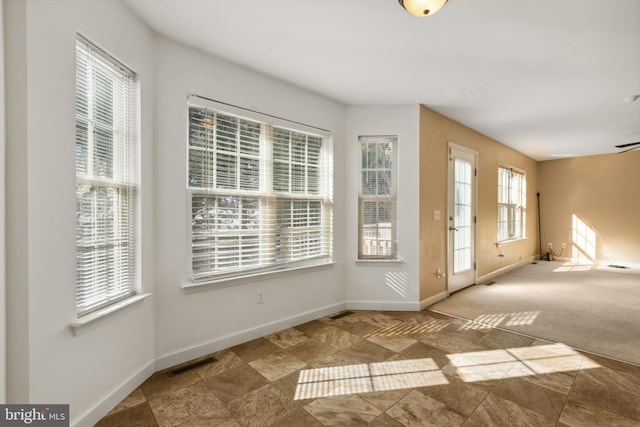 doorway to outside featuring ceiling fan, a healthy amount of sunlight, and carpet flooring