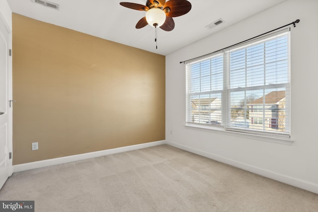 spare room featuring light carpet and ceiling fan