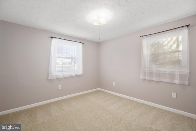 carpeted empty room with a textured ceiling