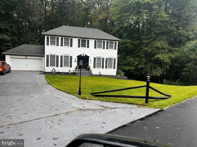 colonial-style house featuring a front yard and a garage