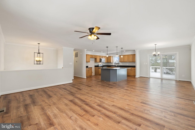 unfurnished living room featuring crown molding, light hardwood / wood-style flooring, and ceiling fan with notable chandelier