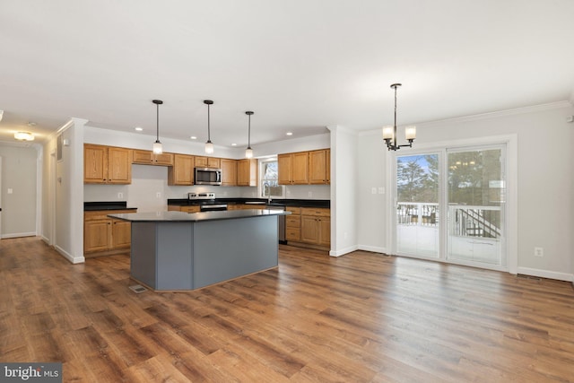 kitchen featuring decorative light fixtures, a center island, stainless steel appliances, and a chandelier