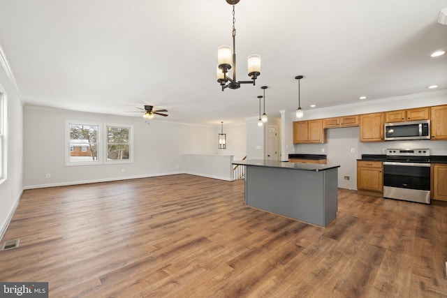 kitchen with appliances with stainless steel finishes, ceiling fan with notable chandelier, hanging light fixtures, and crown molding