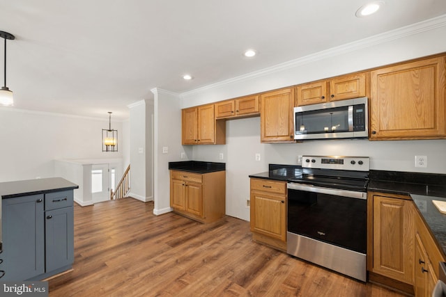 kitchen featuring dark hardwood / wood-style floors, ornamental molding, hanging light fixtures, and appliances with stainless steel finishes