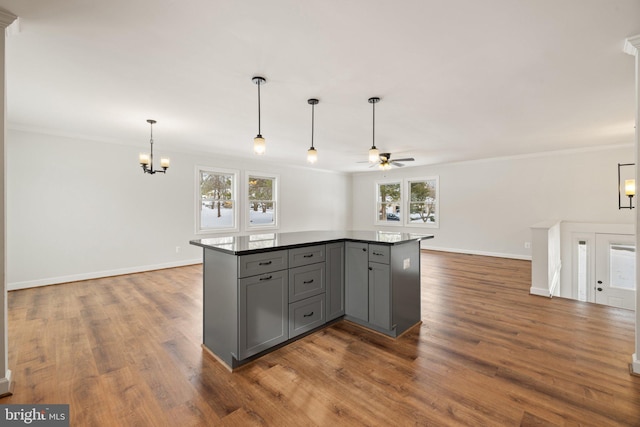 kitchen featuring gray cabinets, crown molding, a healthy amount of sunlight, and ceiling fan with notable chandelier