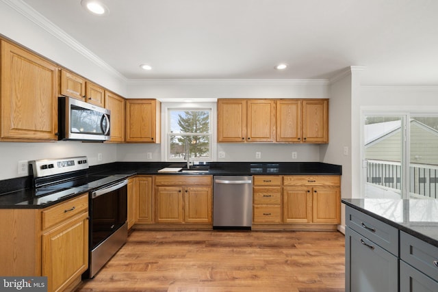 kitchen with appliances with stainless steel finishes, gray cabinets, ornamental molding, and dark stone countertops