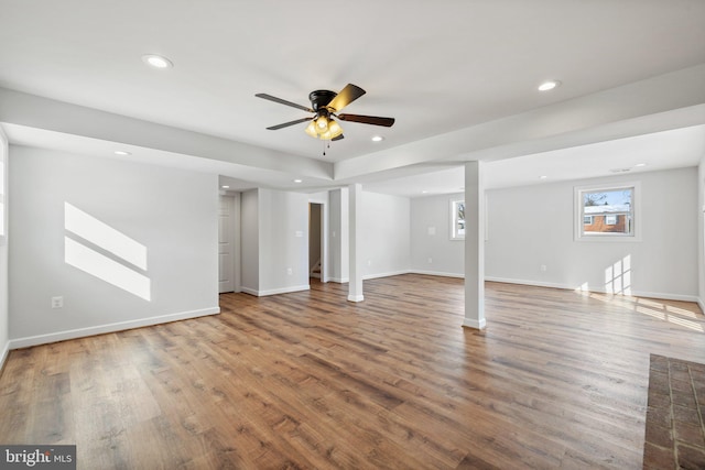 basement featuring wood-type flooring and ceiling fan