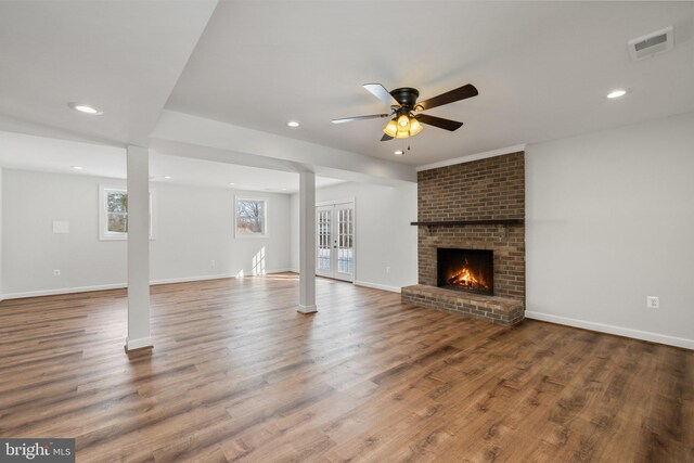 unfurnished living room featuring hardwood / wood-style flooring, ceiling fan, and a fireplace