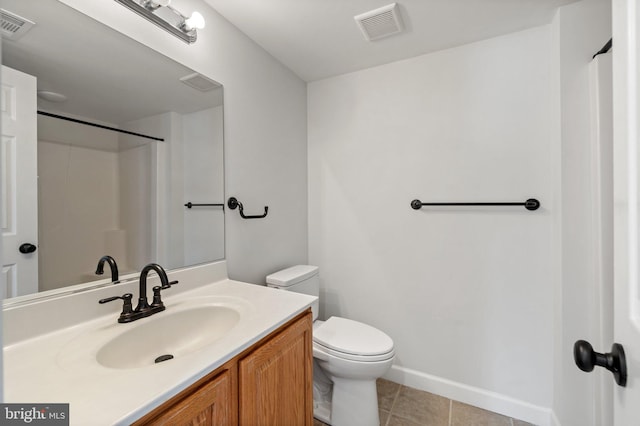 bathroom featuring tile patterned flooring, vanity, and toilet