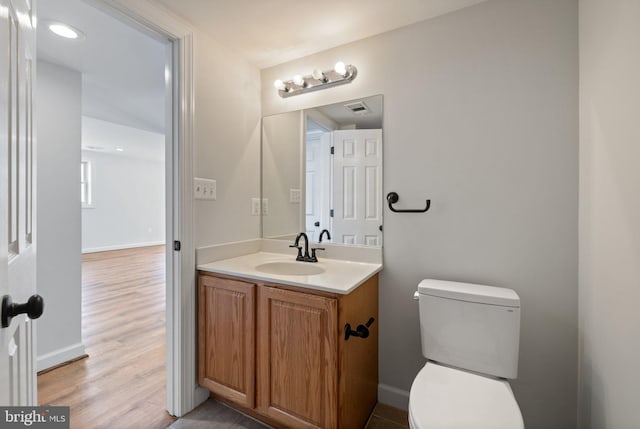 bathroom featuring hardwood / wood-style flooring, vanity, and toilet