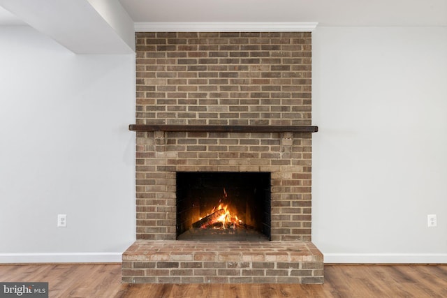 details with hardwood / wood-style floors and a brick fireplace